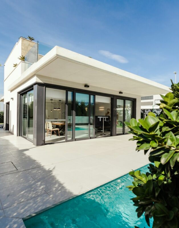 white and grey concrete building near swimming pool under clear sky during daytime