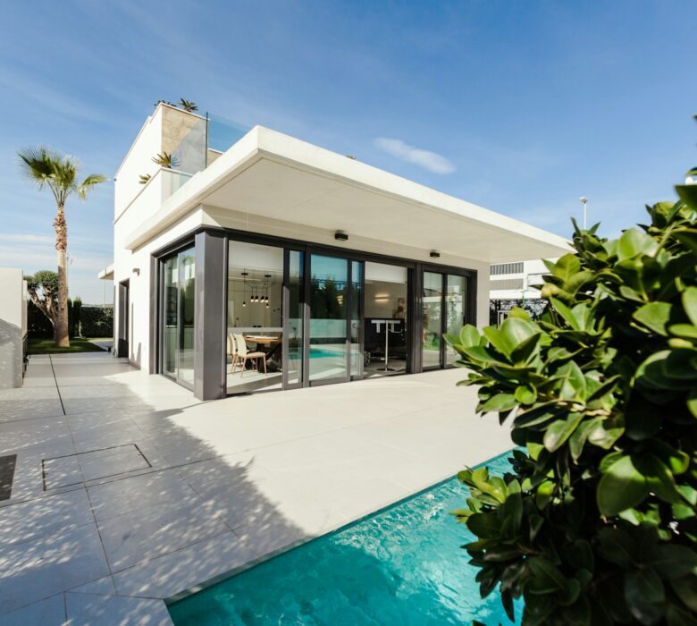 white and grey concrete building near swimming pool under clear sky during daytime