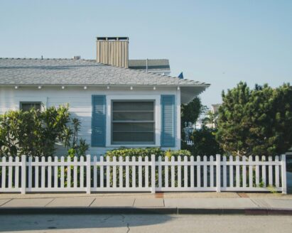 white and blue house beside fence
