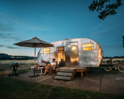 man and woman sitting in front of RV trailer
